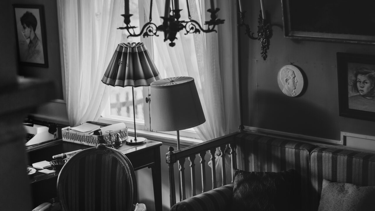 Black and white image of the environment in Doktorsgården - lamps, paintings and furniture are visible.
