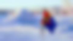 Samisk flagga med vinterlandskap och översnöad kåta diffust i bakgrunden.