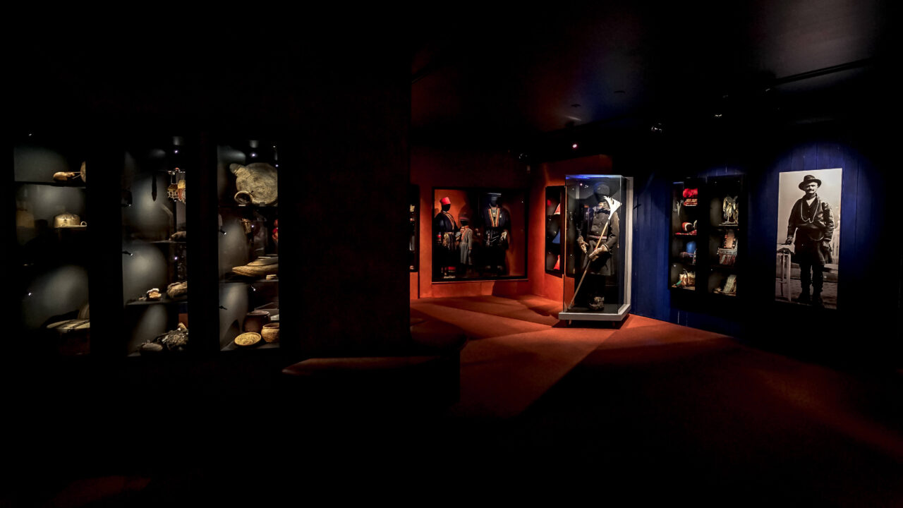 Part of the Silvermuseet's exhibition Mujttalus. Straight ahead you can see some Sami costumes, to the left you can glimpse some utensils such as bags and root objects.