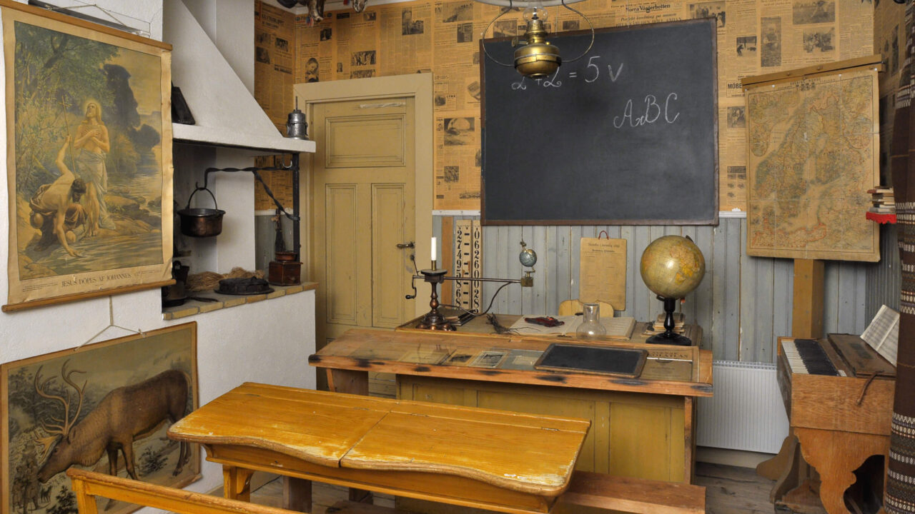 Del av Silvermuseets utställningar som föreställer en gammaldags skolsal. Det är en svart griffeltavla och planscher på väggen, kateder, skolbänkar och tramporgel. Till vänster är det en öppenspis där hemmasydda barnskor (bällingskor och blötnäbbar) har hängts till tork.