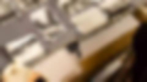 Someone is leafing through an old photo album with black and white photos. One hand with a white cloth glove is visible.