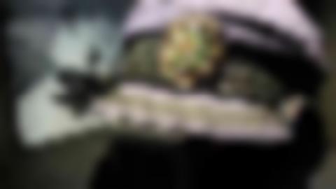 Blue skipper's cap with black band around and on the brim. On the front of the cap is a green star. Behind the cap is a black and white image of a man in a boat.