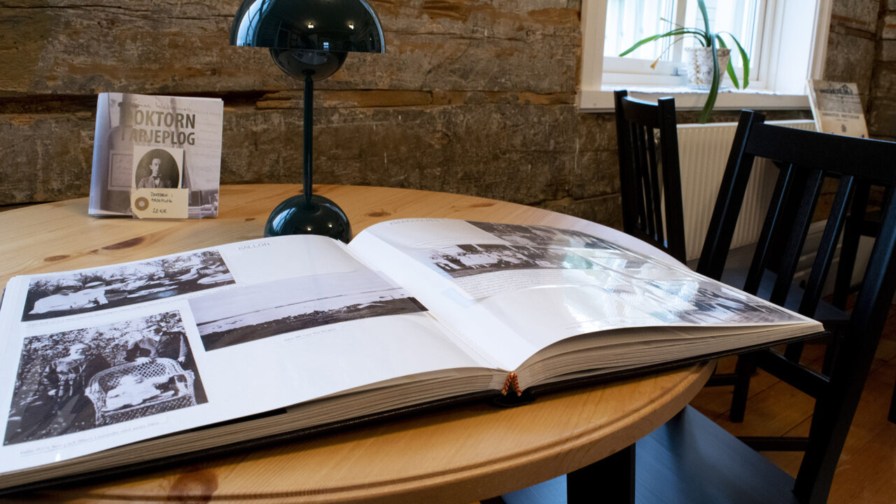 A round table with an open album. The album contains black and white images.
