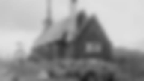 Svartvit bild dåär 12 personer sitter på backen bakom Ammarnäs kyrka.