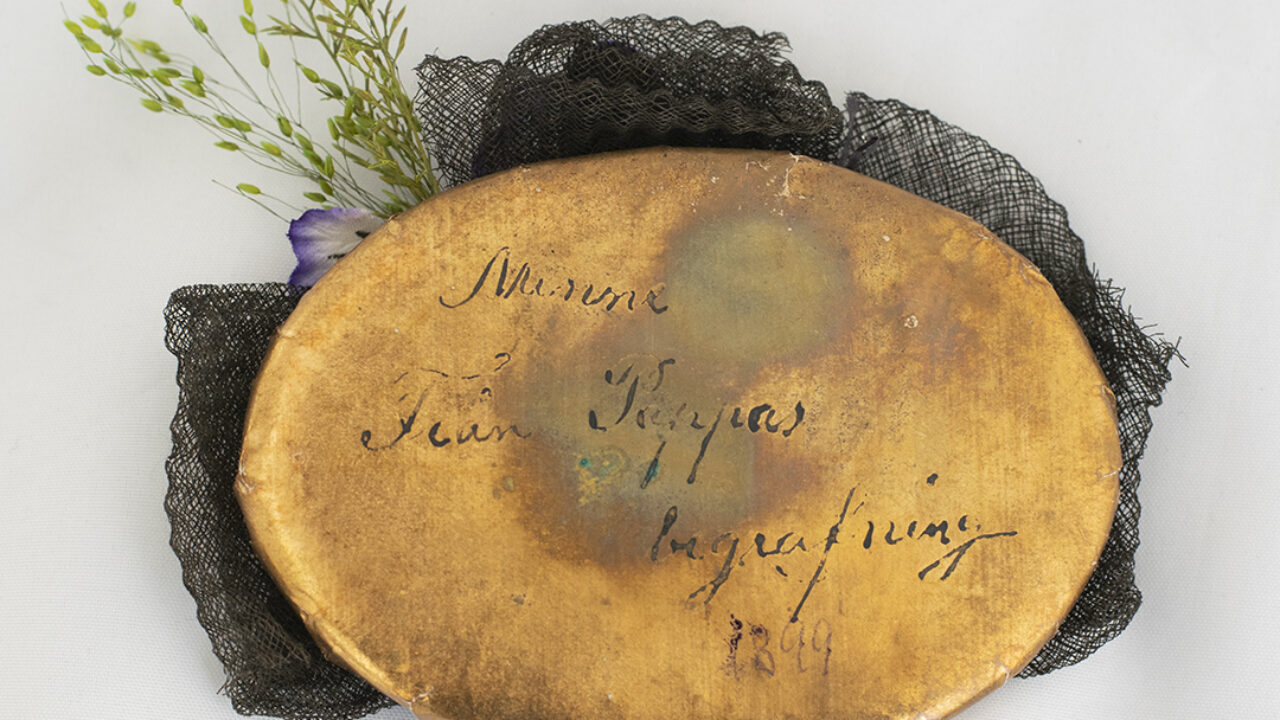 Oval guldig platta med text på.